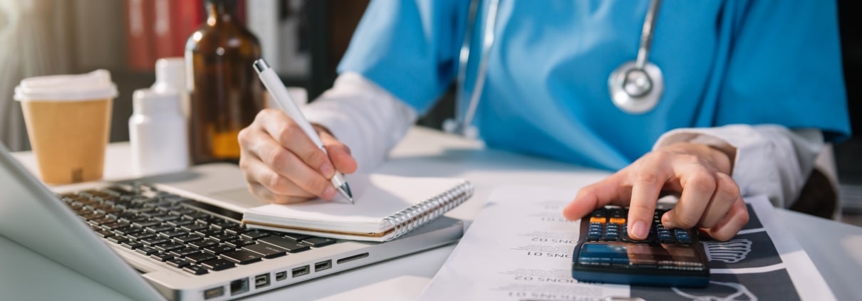 Close up of a medical professional using a calculator