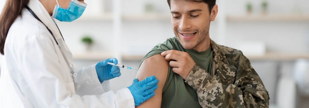 Soldier receiving a shot from a female medical professional